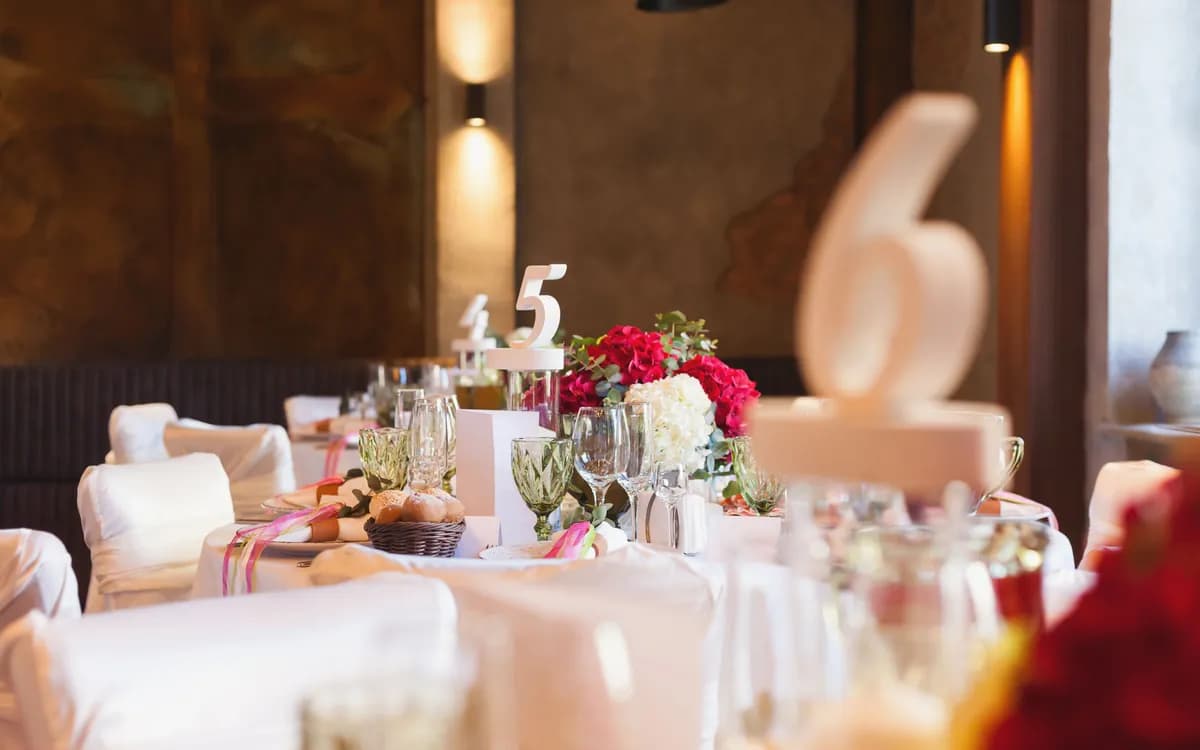 A laid reception table with flowers and a table number