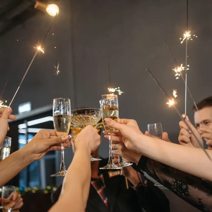 Guests raising champagne glasses and sparklers in a toast