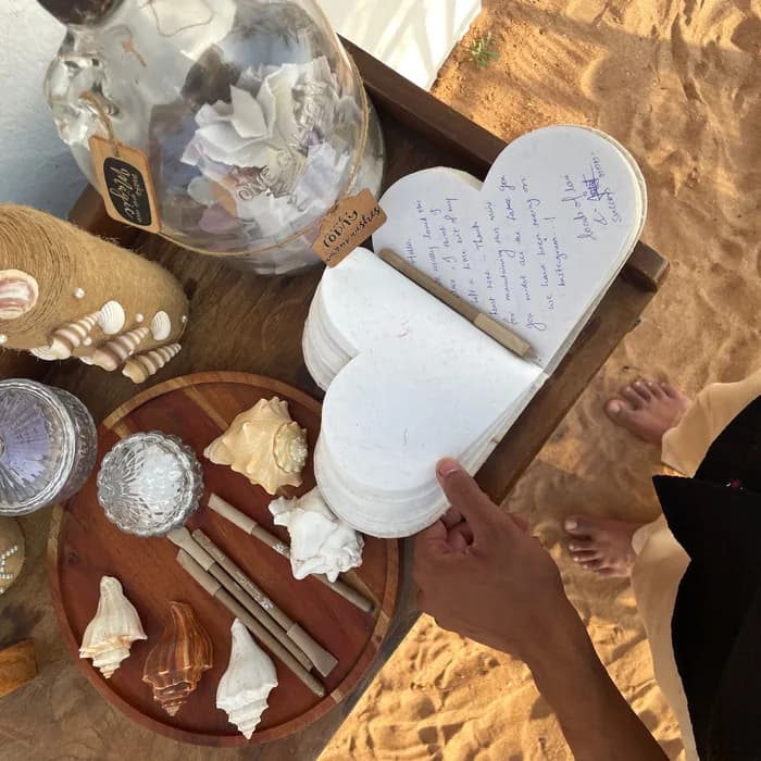 A guest writing a note on a heart-shaped card