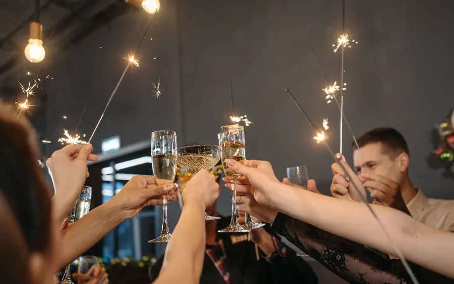 Guests raising champagne glasses and sparklers in a toast