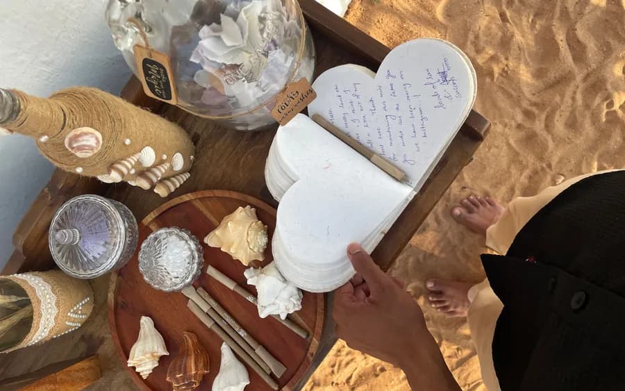 A guest writing a note on a heart-shaped card