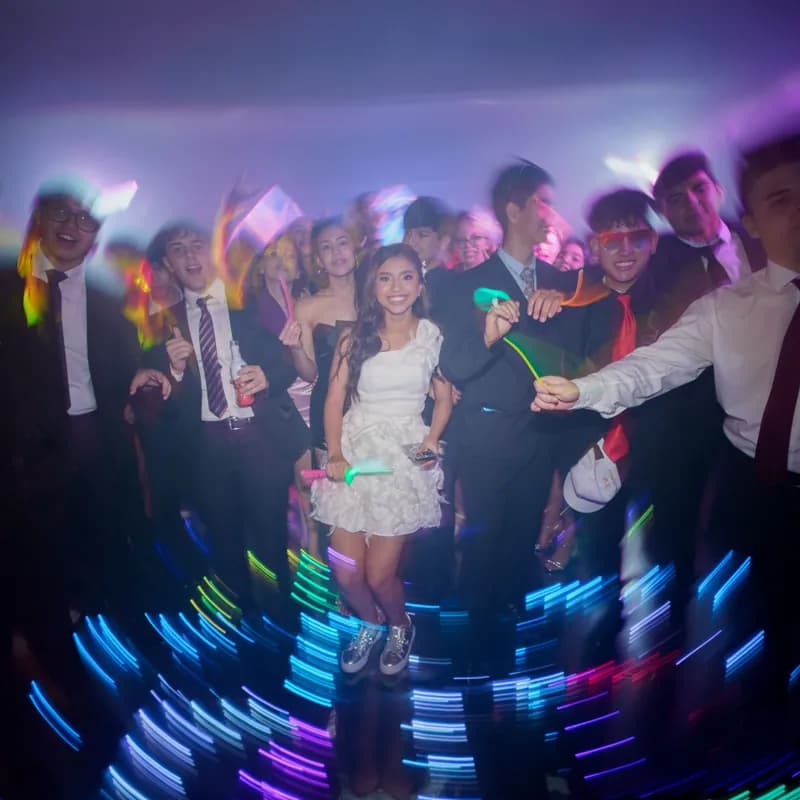 A dance floor lit by glow sticks and coloured light trails